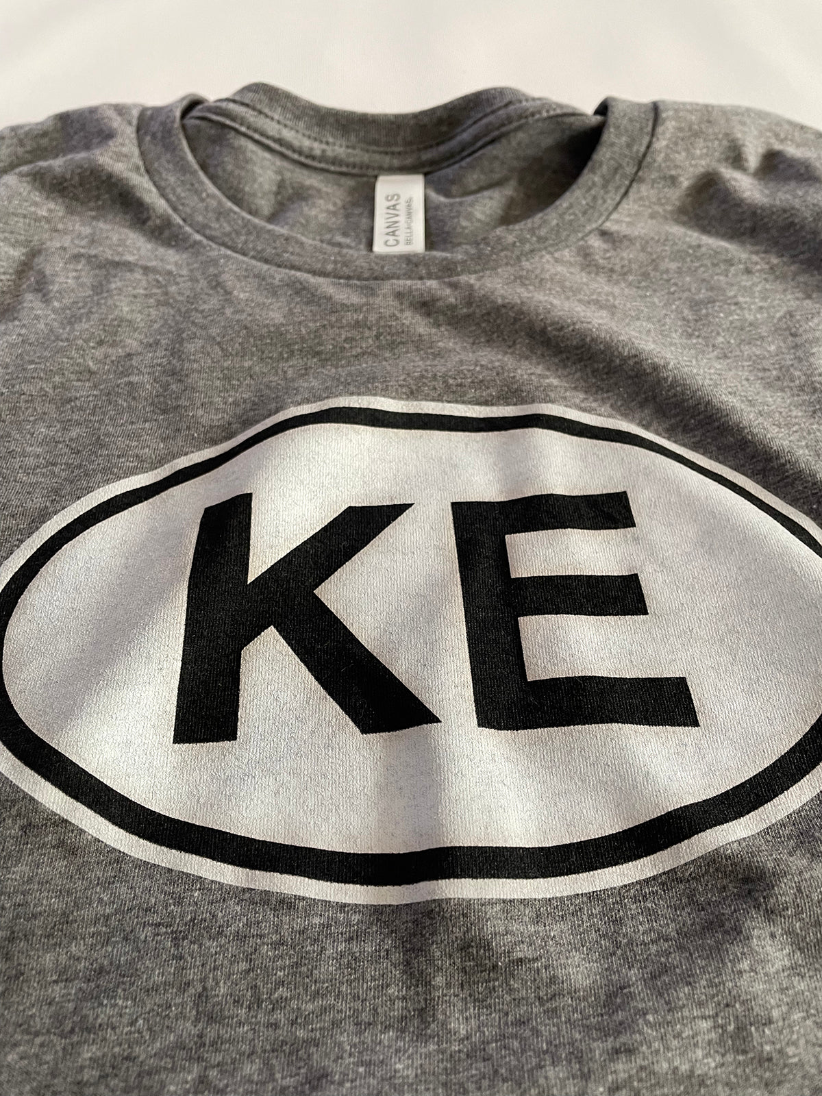 KE oval gray tee