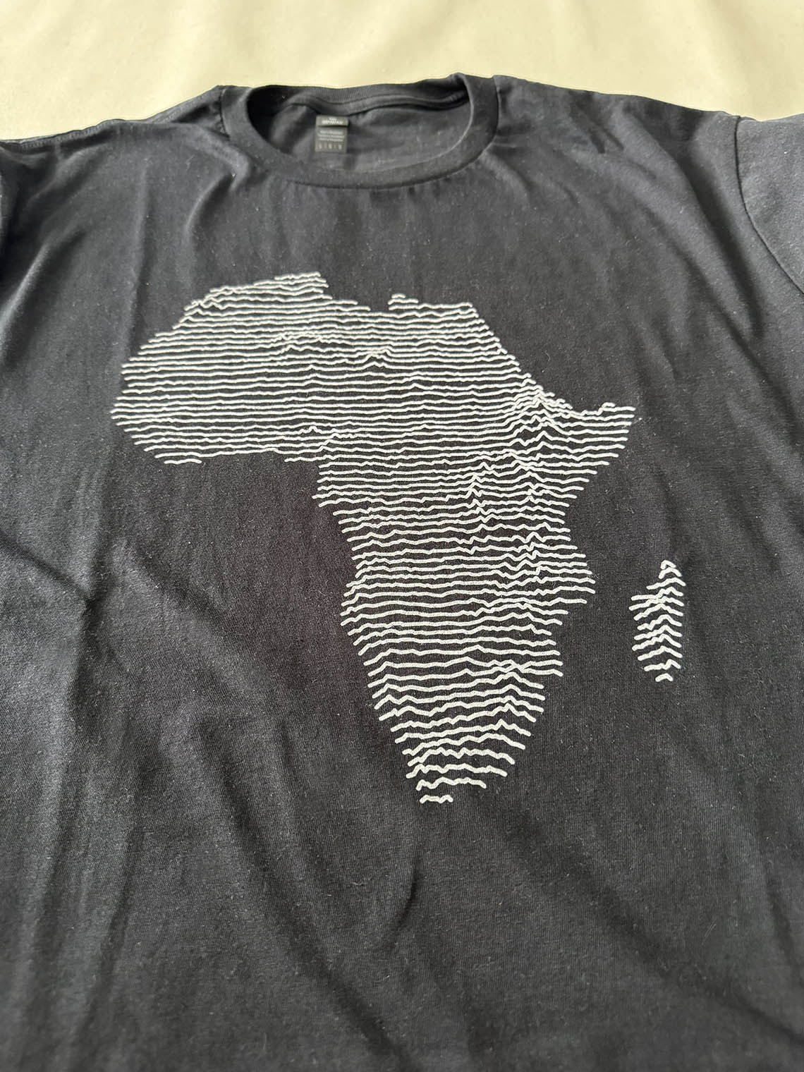 Black t-shirt with medium gray topographical map of Africa design
